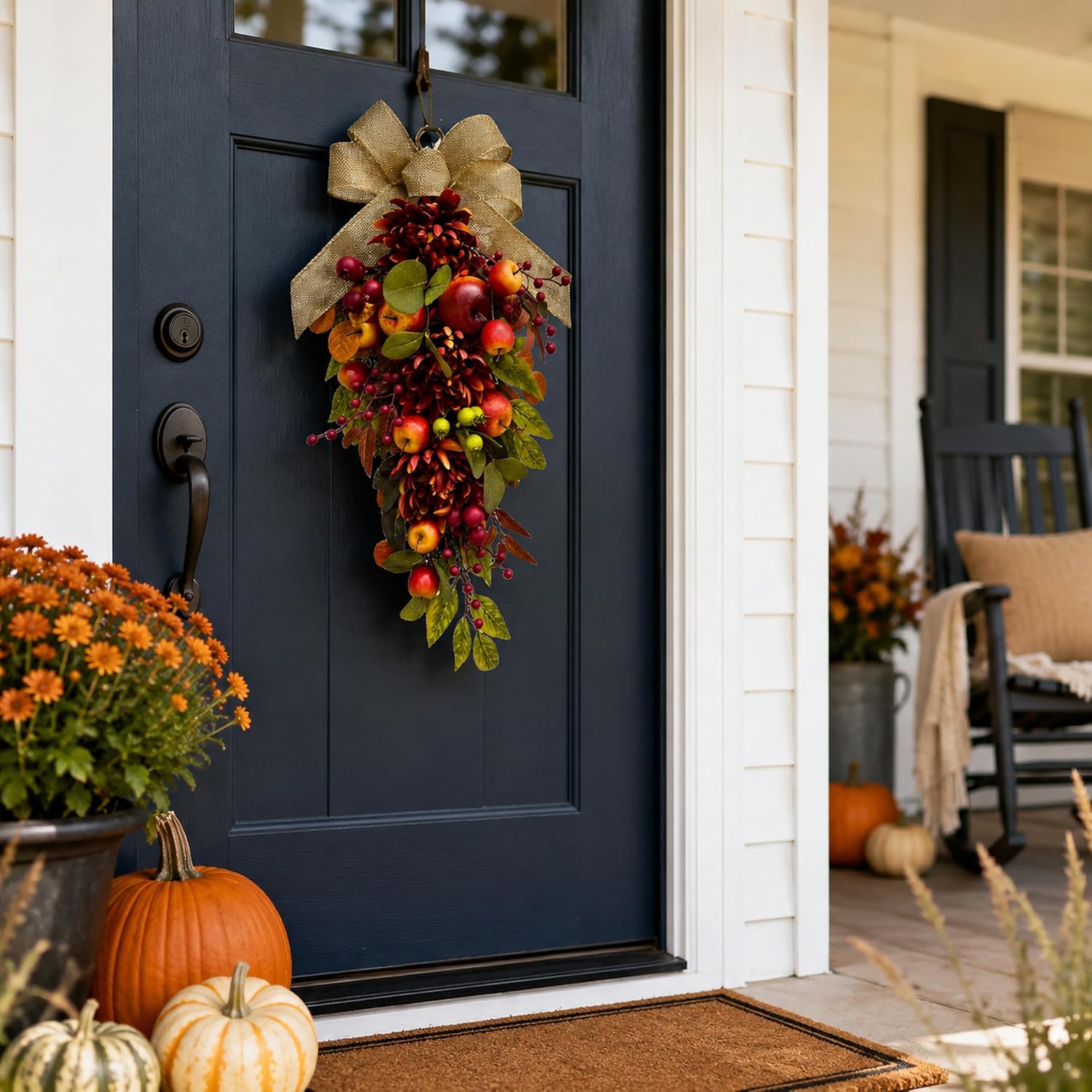 Apple and burgundy mum fall swag displayed on a dark front door